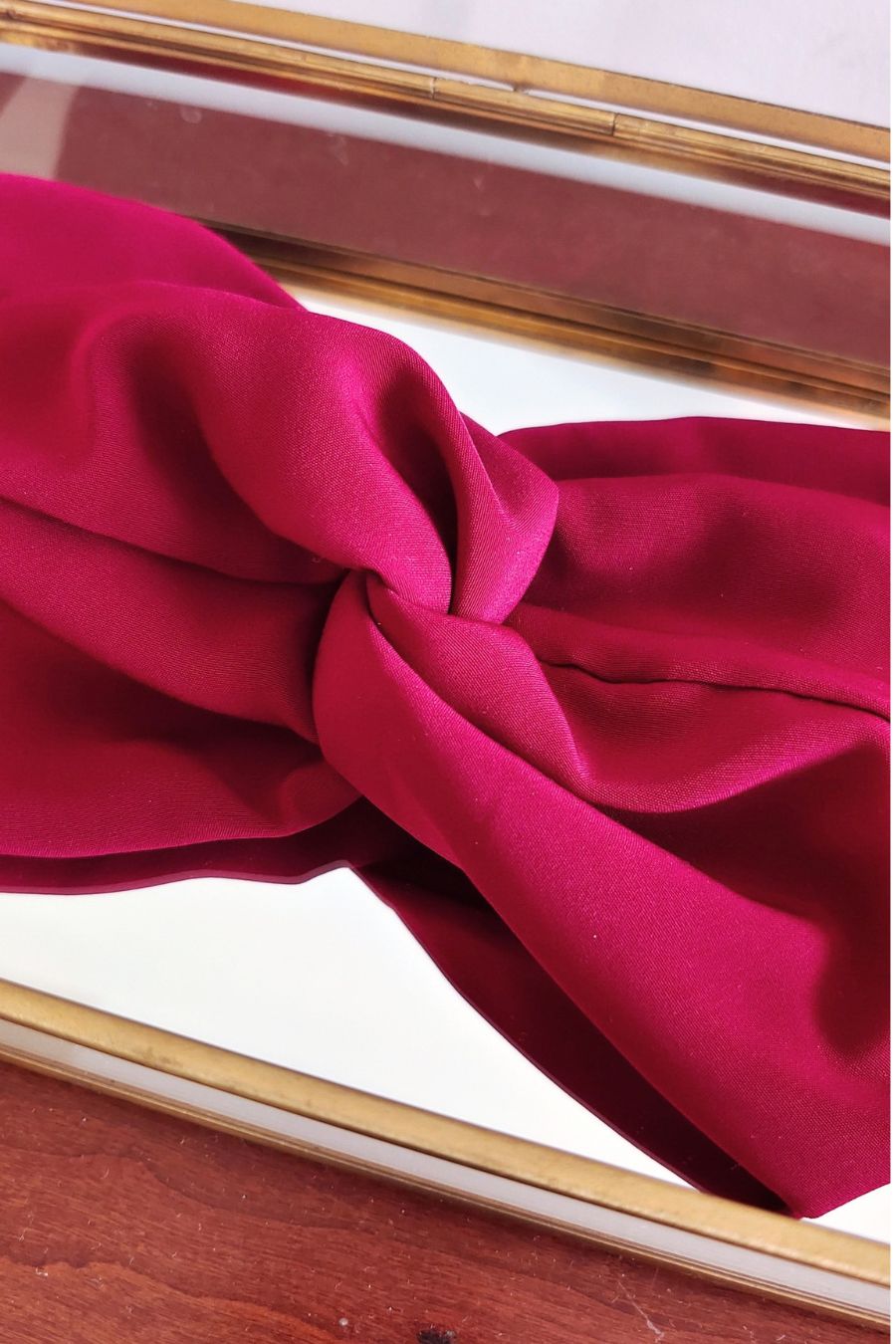 Headband Bordeaux bordeaux en gros plan, nœud central dans une boîte