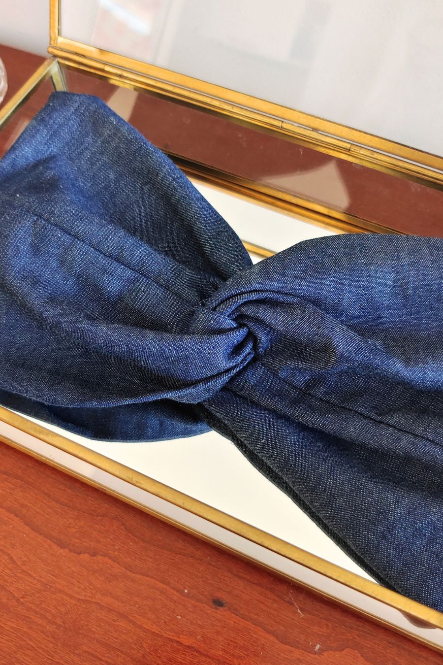 Headband Jean Brut en gros plan dans une boîte vitrée