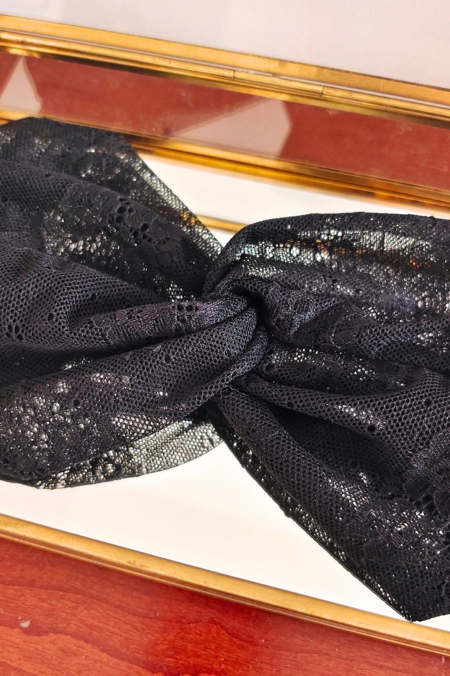 Headband dentelle noire en gros plan dans une boîte vitrée