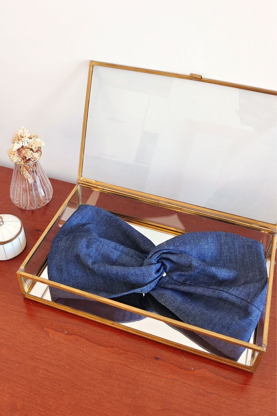 Headband Jean Brut bleu foncé présenté dans une boîte vitrée